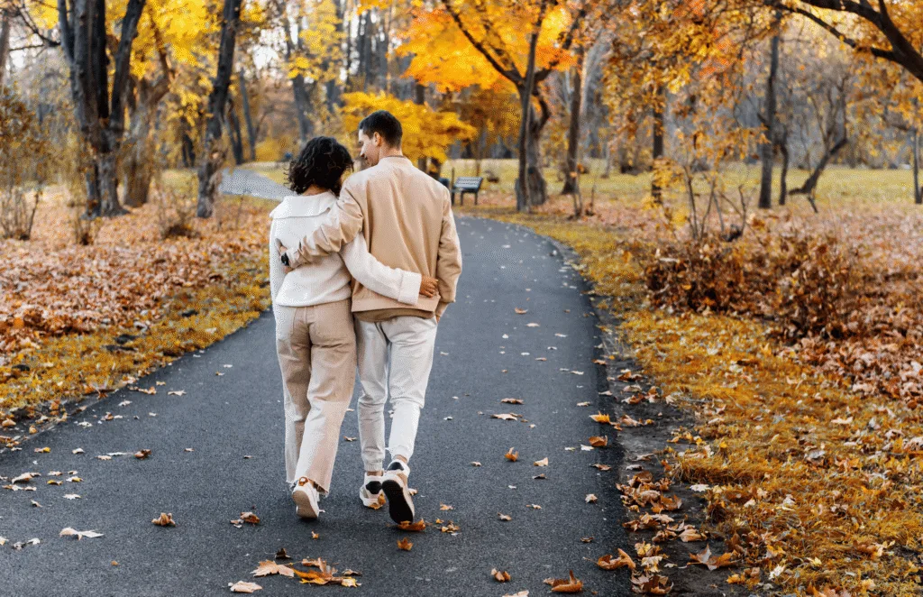 A couple walking together among autumn trees